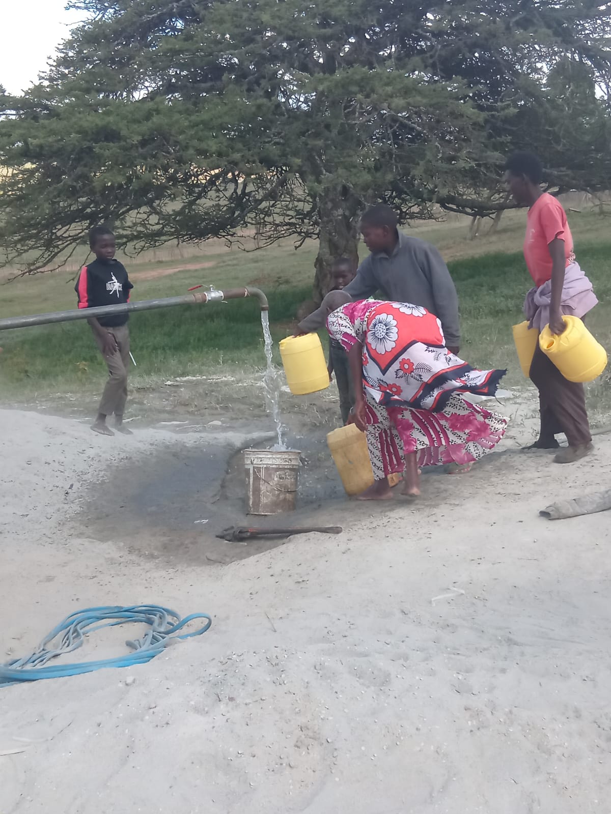 Women filling jerrycans at first water strike Chumvi