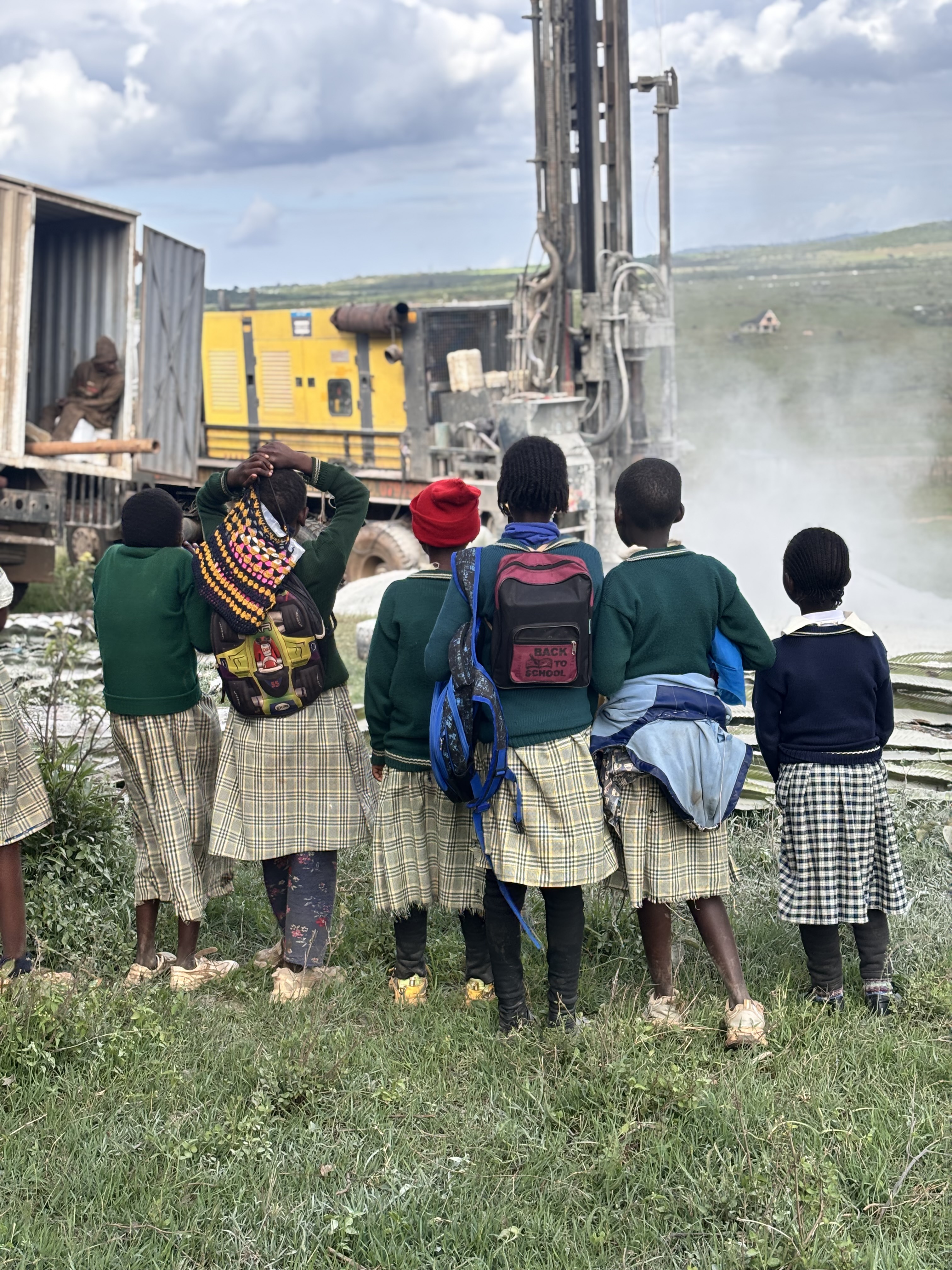 Girls watching drilling crew Chumvi Laikipia