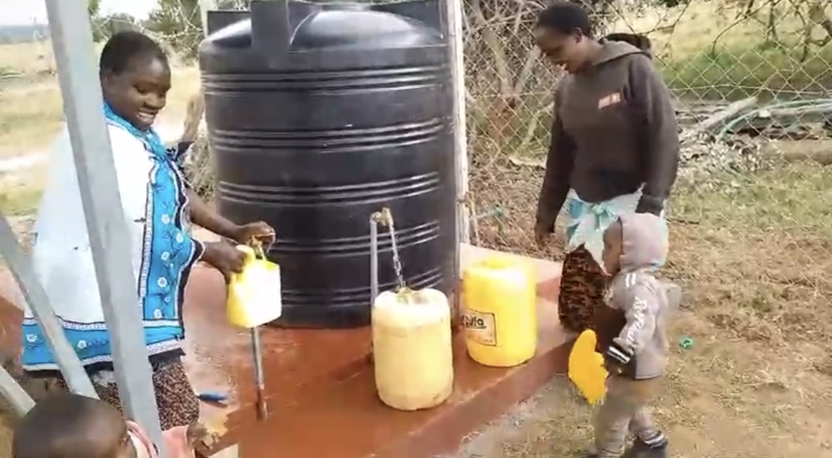 Smiling women and child at Chumvi water tap